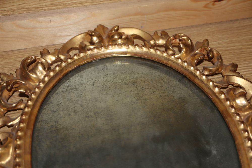 A pair of Venetian circular carved giltwood wall mirrors and another similar mirror